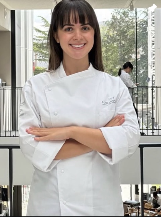 Chef Gaby Melo decorando um bolo na sua confeitaria